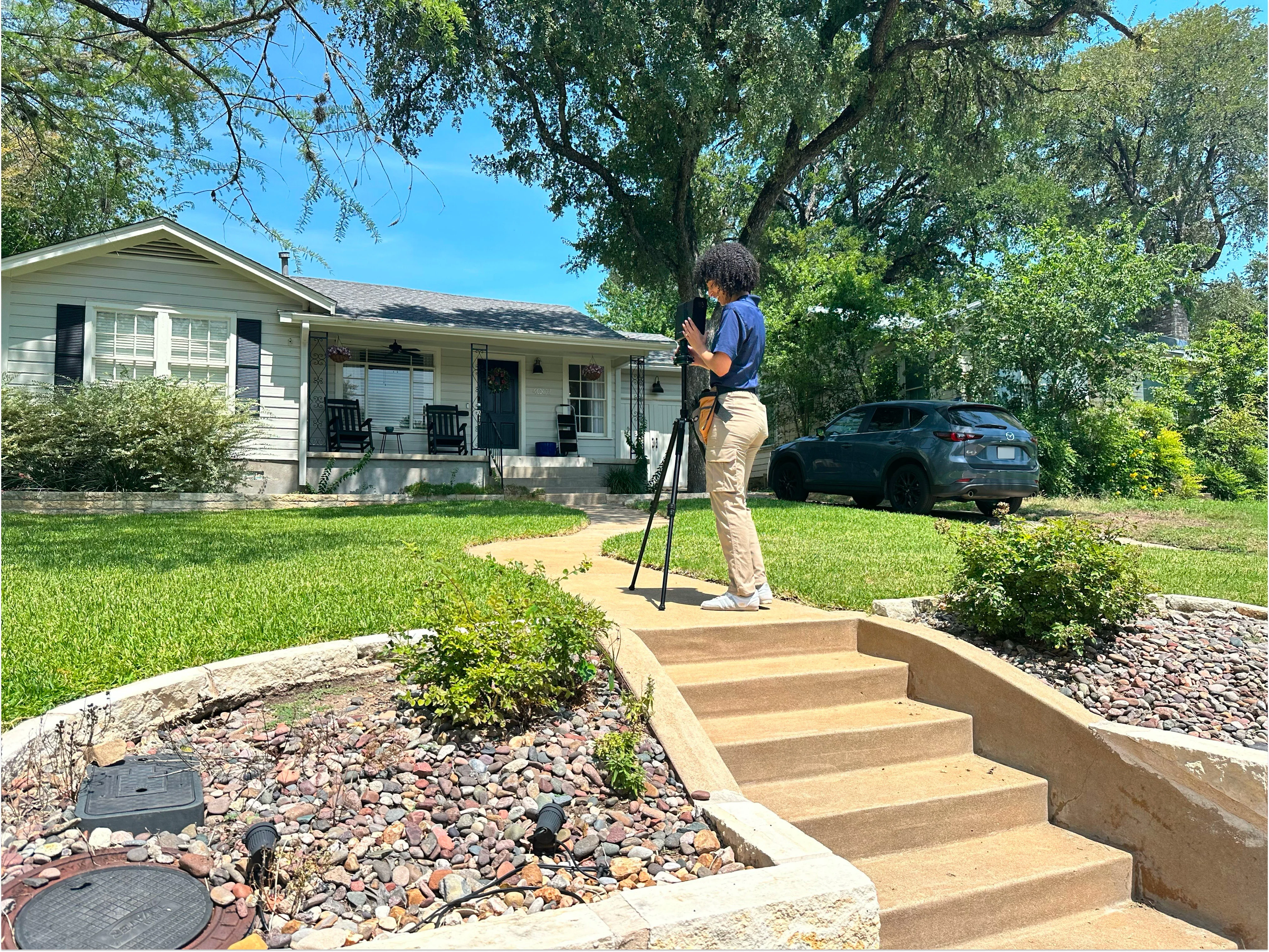 Inventory Specialist using a Matterport camera outside a residential home